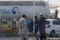 アブダビ国営石油会社（ADNOC）の貯蔵施設で、燃料タンクの近くに立つ人。アラブ首長国連邦（UAE）の首都アブダビの工業地区で（2022年1月17日撮影）。(c)AFP