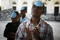 ハイチの首都ポルトープランス（Port-au-Prince）で、地震で倒壊した教会の敷地で祈りをささげる被災者ら（2010年1月24日撮影）。(c)AFP/ JEAN-PHILIPPE KSIAZEK