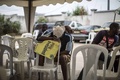 選挙結果を一晩待ち、居眠りをする野党支持者。(c)AFP/MARCO LONGARI