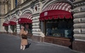 ロシア・モスクワ中心部にある老舗百貨店「グム」で、閉店した伊高級ブランド「グッチ」のショーウインドーの写真を撮影する女性（2022年3月16日撮影）。(c)AFP