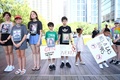 米テキサス州ヒューストンで開催された全米ライフル協会（NRA）年次総会の会場前で、小学校乱射事件で犠牲となった児童の写真を手に抗議に参加する子どもたち（2022年5月22日撮影）。(c)Patrick T. FALLON / AFP