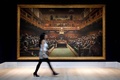 英ロンドンで、競売に先立ち報道関係者に公開されたバンクシーの絵画「退化した議会」の前を歩くギャラリー職員（2019年9月27日撮影）。(c)Tolga Akmen / AFP