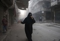 政府軍が「たる爆弾」を投下したとされるシリア北部のアレッポの通りを逃げる女性と子供（2015年5月30日撮影）。(c)AFP/KARAM AL-MASRI