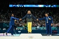 パリ五輪、体操女子種目別ゆか決勝。表彰台で手をつなぐ（右から）銅メダルを獲得した米国のジョーダン・チャイルズ選手、金メダルを獲得したブラジルのレベッカ・アンドラーデ選手、銀メダルを獲得した米国のシモーネ・バイルス選手（2024年8月5日撮影）。(c)Gabriel BOUYS / AFP