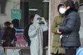 中国・武漢の病院で、体温計を見つめる防護服を着た看護師（2020年1月24日撮影）。(c)AFP/Hector RETAMAL