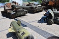 ウクライナの首都キーウで、聖ミハイル黄金ドーム修道院前に展示されたロシア軍の兵器に腰掛け本を読む人（2022年7月26日撮影）。(c)Sergei SUPINSKY / AFP
