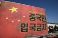 韓国・ソウルの景福宮前で、「中国人の入国を禁止せよ」と記した赤い横断幕を掲げ、新型コロナウイルスの水際対策強化を韓国政府に迫る韓国人ら（2020年2月3日撮影）。(c)Jung Yeon-je / AFP