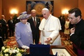 バチカンを訪問した英国のエリザベス女王（Queen Elizabeth II、左）とフィリップ殿下（Prince Philip、中央）に贈り物を進呈するローマ・カトリック教会のフランシスコ（Francis）法王（右から2人目、2014年4月3日撮影）。(c)AFP/STEFANO RELLANDINI