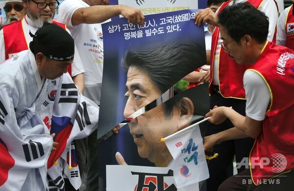 ソウルの日本大使館近くで抗議デモ、安倍首相の顔写真切る参加者も