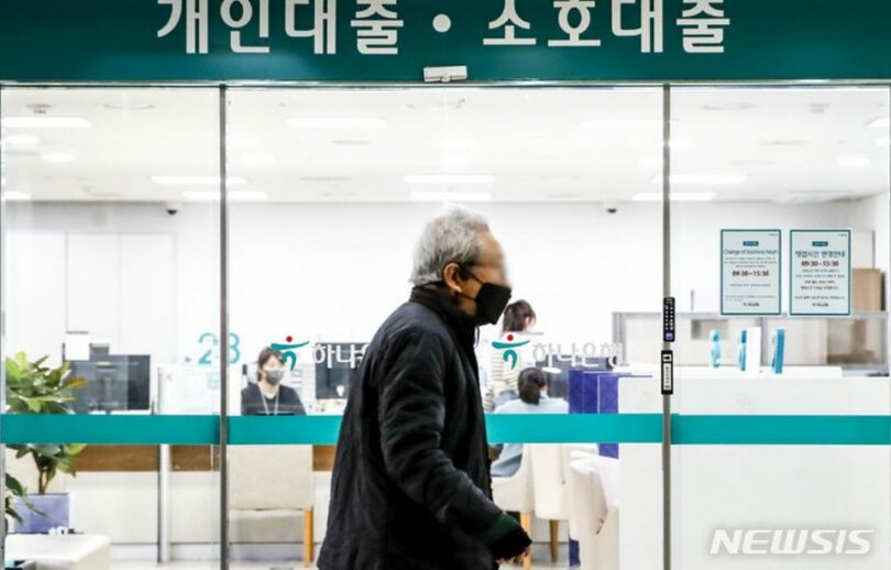 昨年12月13日、ソウル市内の銀行貸出窓口前を歩く市民(c)NEWSIS