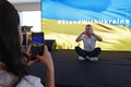 ドバイ万博のウクライナ館で、「#StandWithUkraine（ウクライナと共に）」と表示されたスクリーンの前で写真を撮る人々。アラブ首長国連邦（UAE）ドバイで（2022年2月27日撮影）。(c)Giuseppe CACACE / AFP