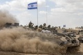 パレスチナ自治区ガザ（Gaza）地区との境界付近を、イスラエル国旗を掲げ移動するイスラエル軍の兵員輸送装甲車（2014年7月25日撮影）。(c)AFP/JACK GUEZ