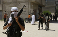 パレスチナ自治区ガザ市（Gaza City）のラファ（Rafah）にあるモスクでイスラム過激派集団「神の戦士（Jund Ansar Allah）」の指導者Abdul Latif Musa師が礼拝を行った後に教会前を警備する同集団のメンバー（2009年8月14日撮影）。(c)AFP/SAID KHATIB