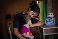 インドネシア・西スラウェシ州マムジュで、乳児を抱く少女。2017年に結婚した（2019年2月9日撮影）。(c)YUSUF WAHIL / AFP