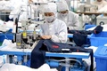北京冬季五輪の関係者が着用する防護服を作る作業員。中国・山東省浜州市で（2022年1月27日撮影）。(c)AFP