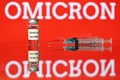 「オミクロン」と表示されたスクリーンの前に置かれた注射器（2021年12月2日撮影、資料写真）。(c)Justin TALLIS / AFP