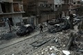 シリア首都ダマスカス近郊の反体制派支配地区、東グータで、政権軍による空爆後、損壊した建物の横を歩く男性（2018年2月25日撮影）。(c)AFP PHOTO / HAMZA AL-AJWEH