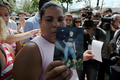 銃乱射事件のあった、ブラジル・リオデジャネイロ（Rio de Janeiro）の公立学校で、犠牲になった生徒の写真を見せる親戚の女性（2011年4月7日撮影）。(c)AFP/ANTONIO SCORZA
