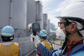 東京電力福島第1原子力発電所の汚染水貯留タンク周辺の放射能レベルを測定する職員（2018年7月27日撮影、資料写真）。(c)KIMIMASA MAYAMA / POOL / AFP