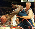 Golden State Warriors Chris Mullin (R) tries to knock the ball loose from New York Knicks Charles Oakley during the first period 16 November in Oakland, California. (c)AFP/JOHN G. MABANGLO