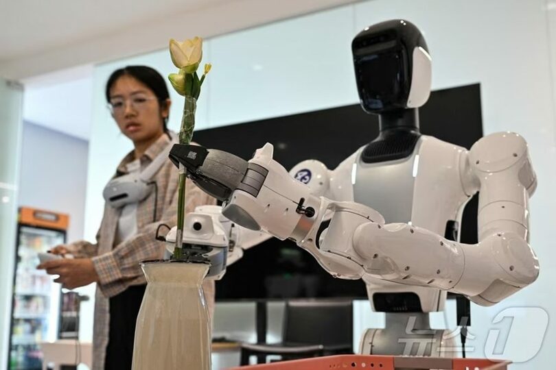 中国広東省深圳のロボット企業施設で、ヒューマノイドロボットに家事動作を学習させるエンジニア(c)AFP/news1