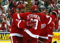写真は、チーム3点目を決めてレッドウィングスのヘンリク・ゼッターバーグ（%%Henrik Zetterberg%%、中央）から祝福を受けるミカエル・サミュエルソン（%%Mikael Samuelsson%%、左）。(c)AFP/Getty Images Dave Sandford