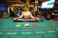 シンガポール・セントーサ（Sentosa）島の総合リゾート施設「リゾート・ワールド・セントーサ（Resorts World Sentosa）」内にオープンした初の合法カジノで客を待つディーラー（2010年12月14日撮影）。(c)AFP/ROSLAN RAHMAN