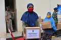 インドネシアのジャカルタにある空軍の倉庫で、新型コロナウイルス感染症（COVID-19）の流行に伴い支援物資を受け取る人々（2020年5月11日撮影）。(c)ADEK BERRY / AFP