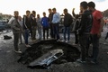 イラクの首都バグダッド南部の中古車市場で起きた自動車爆弾攻撃の現場に集まった人々（2017年2月16日撮影）。(c)AFP