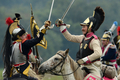 フランス皇帝ナポレオン（Napoleon）の遠征軍と帝政ロシア軍が激戦を繰り広げた1812年の「ボロジノの戦い」から今年で200年となることを記念し、モスクワ（Moscow）西方のボロジノ（Borodino）で2日、戦いを再現するイベントが行われた。

　当時の軍服や刀剣などを用いて戦いを忠実に再現したイベントには、ロシア政府が110万ドル（約8700万円）を出資。フランス側1550人、ロシア側1450人の兵士を演じる計3000人が参加。ジスカール・デスタン（Giscard d&apos;Estaing）仏元大統領と、ウラジーミル・プーチン（Vladimir Putin）露大統領も「観戦」に訪れた。これに先立ち、プーチン大統領の補佐官は「ボロジノの戦い」再現イベントを「若者の愛国教育」を広めるために活用したいと述べた。

　1812年9月7日の「ボロジノの戦い」は合戦では勝利しながら、戦争には負けた戦将の際立った例だ。

　ボロジノでは2万人のナポレオン軍が激戦の末に、兵力の多い4万5000人の露軍を破った。しかし痛手が大きかったため、ナポレオンはモスクワに進軍を開始する前に回復期間を置くことにした。この時にナポレオンはおそらく、敵方のクトゥーゾフ将軍が戦闘の翌日に一時撤退したことを知らなかったとされる。この休息の決断が、ナポレオンにとって致命的な誤算だった。

　帝政ロシア軍は兵力の半分を失っていたが、近くの村落で体制を立て直す時間ができ、戦術を練った。ナポレオン軍が入城したモスクワは、市民は脱出しもぬけの殻で、そこに焦土戦術が追い打ちをかけた。士気を失ったナポレオン軍は退却を余儀なくされた（2012年9月2日撮影）。(c)AFP/Kirill Kudryavtsev