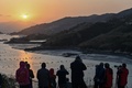 中国福建省・霞浦県で、夕日の写真を撮る観光客ら（2019年12月12日撮影）。(c)HECTOR RETAMAL / AFP