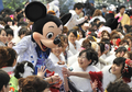 成人の日の9日、千葉県浦安（Urayasu）市の成人式が東京ディズニーランド（Tokyo Disneyland）で開かれた。政府統計によると、1日現在20歳の新成人の人口は122万人で、最も多かった1970年の246万人の半数を初めて割り込んだ。

写真は、ミッキーマウスから祝福されて大喜びの晴れ着姿の新成人たち（2012年1月9日撮影）。(c)AFP/ KAZUHIRO NOGI