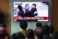 北朝鮮の平壌に到着した韓国の文在寅大統領と、出迎えた北朝鮮の金正恩朝鮮労働党委員長を映したテレビ画面（2018年9月18日撮影）。(c)Jung Yeon-je / AFP
