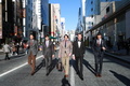 12月16日にダンヒル銀座本店で行われたモデル5人によるイベントの様子。ダンヒルの旗を持ったモデルたちは、最新コレクションに身を包んで銀座の街を闊歩した（2012年12月16日撮影）。(c)Alfred Dunhill