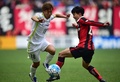 サッカーAFCチャンピオンズリーグ、グループF第2節、FCソウル対サンフレッチェ広島。FCソウルの高光民（右）とボールを競るサンフレッチェ広島の柏好文（2016年3月1日撮影）。(c)AFP/JUNG YEON-JE