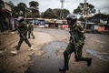 ケニアの首都ナイロビのスラム街キベラで、大統領選結果の抗議デモ参加者を追う治安部隊員（2017年8月12日撮影）。(c)AFP/MARCO LONGARI