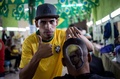 ブラジル・リオデジャネイロ（Rio de Janeiro）の理髪店で、男性客の後頭部にサッカー男子ブラジル代表のネイマール（Neymar da Silva Santos Junior）選手の肖像を施した理髪師（2014年6月27日撮影）。(c)AFP/YASUYOSHI CHIBA