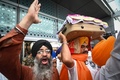 インドの首都にあるデリー国際空港で、アフガニスタンから退避してきたシーク教徒が持ち帰った同教の聖典「グル・グラント・サーヒブ」を運ぶ男性（2021年8月24日撮影）。(c)Money SHARMA / AFP