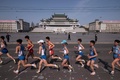 北朝鮮・平壌で開催された平壌国際マラソンで、金日成広場前を走る出場者たち（2017年4月9日撮影）。(c)AFP/Ed JONES
