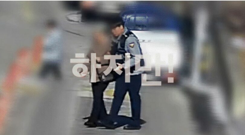 被害女性に寄り添いながら銀行に向かう警察官=韓国警察庁公式YouTube(c)NEWSIS