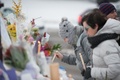 カナダ・ケベックシティーで、銃撃事件が起きたモスクの近くにろうそくを手向けて犠牲者を追悼する人々（2017年2月1日撮影）。(c)AFP/Alice Chiche