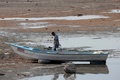 メキシコ・ハリスコ州のチャパラ湖で、元の湖岸から約200メートル離れた場所に船を止め魚を運ぶ漁師（2024年6月6日撮影）。(c)Ulises Ruiz / AFP
