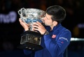 全豪オープンテニス、男子シングルス決勝。表彰式でトロフィーにキスするノバク・ジョコビッチ（2016年1月31日撮影）。(c)AFP/WILLIAM WEST