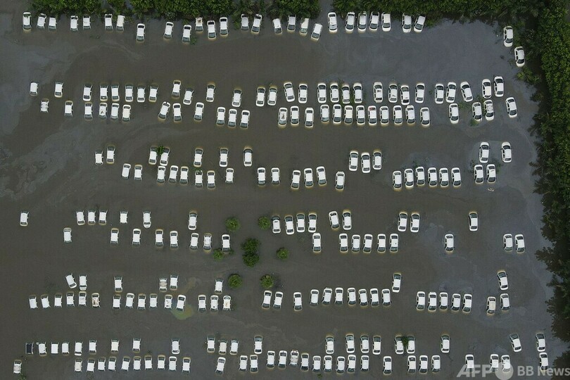 【今日の1枚】駐車場冠水、油浮く水に白の車列 インド