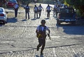 メキシコ西部ミチョアカン（Michoacan）州のヌエバ・イタリア（Nueva Italia）の町中を歩く自警団のメンバー（2014年1月12日撮影）。(c)AFP/ALFREDO ESTRELLA
