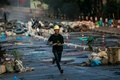 ミャンマー最大都市ヤンゴンで、剣を手に走るデモ参加者（2021年3月16日撮影）。(c)STR / AFP