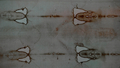 イタリア・トリノ（Turin）の大聖堂で公開された「トリノの聖骸布（Shroud of Turin）」に浮き上がるイエス・キリスト（Jesus Christ）とされる人物の顔（右）と手（中央、2010年4月10日撮影）。(c)AFP/VINCENZO PINTO