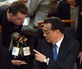 豪首都キャンベラの国会議事堂で行われた昼食会で、ウエーターにワインについて尋ねる中国の李克強首相（右、2017年3月23日撮影）。(c)AFP/MARK GRAHAM