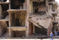シリア北東部カーミシュリーで、破壊された建物の前をおもちゃの銃を手に歩く男の子（2016年9月13日撮影）。(c)AFP/DELIL SOULEIMAN