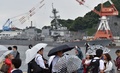 神奈川県横須賀市の南西沖でフィリピン船籍のコンテナ船と衝突した米海軍イージス駆逐艦「フィッツジェラルド」を見る人たち。横須賀港で（2017年6月18日撮影）。(c)AFP/Kazuhiro NOGI
